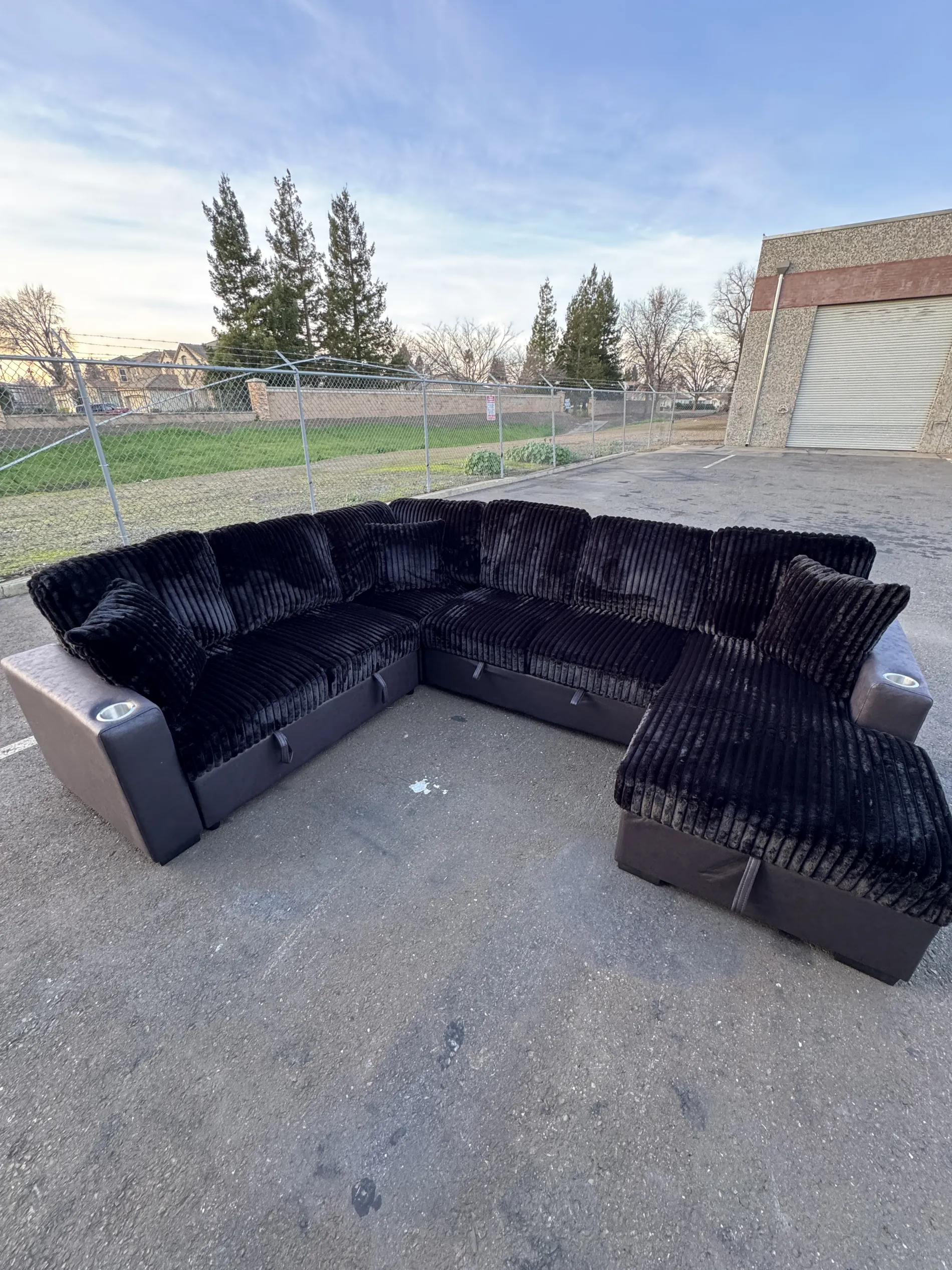 Black plush sectional photographed outdoors
