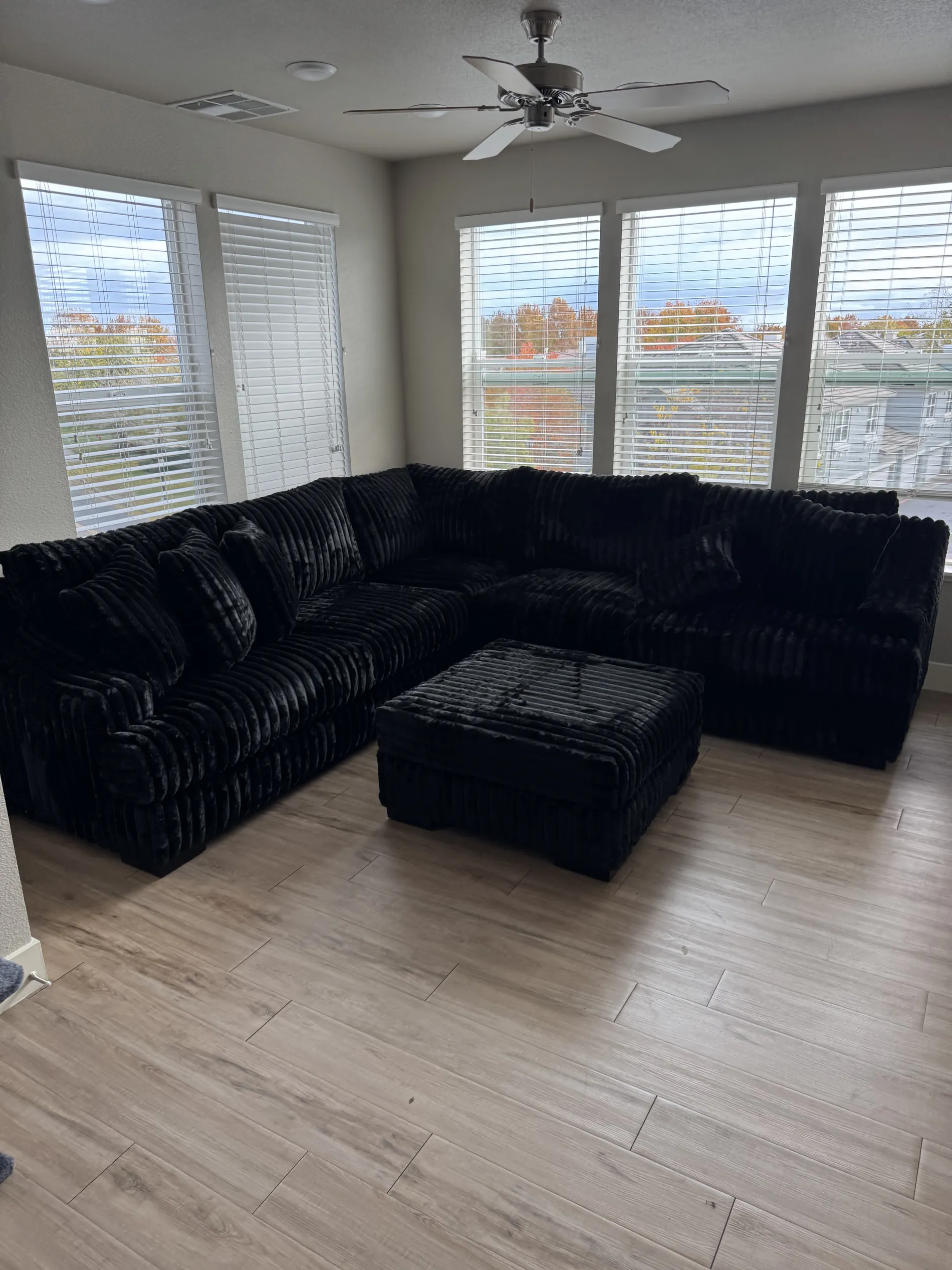 Custom black plush sectional with matching ottoman