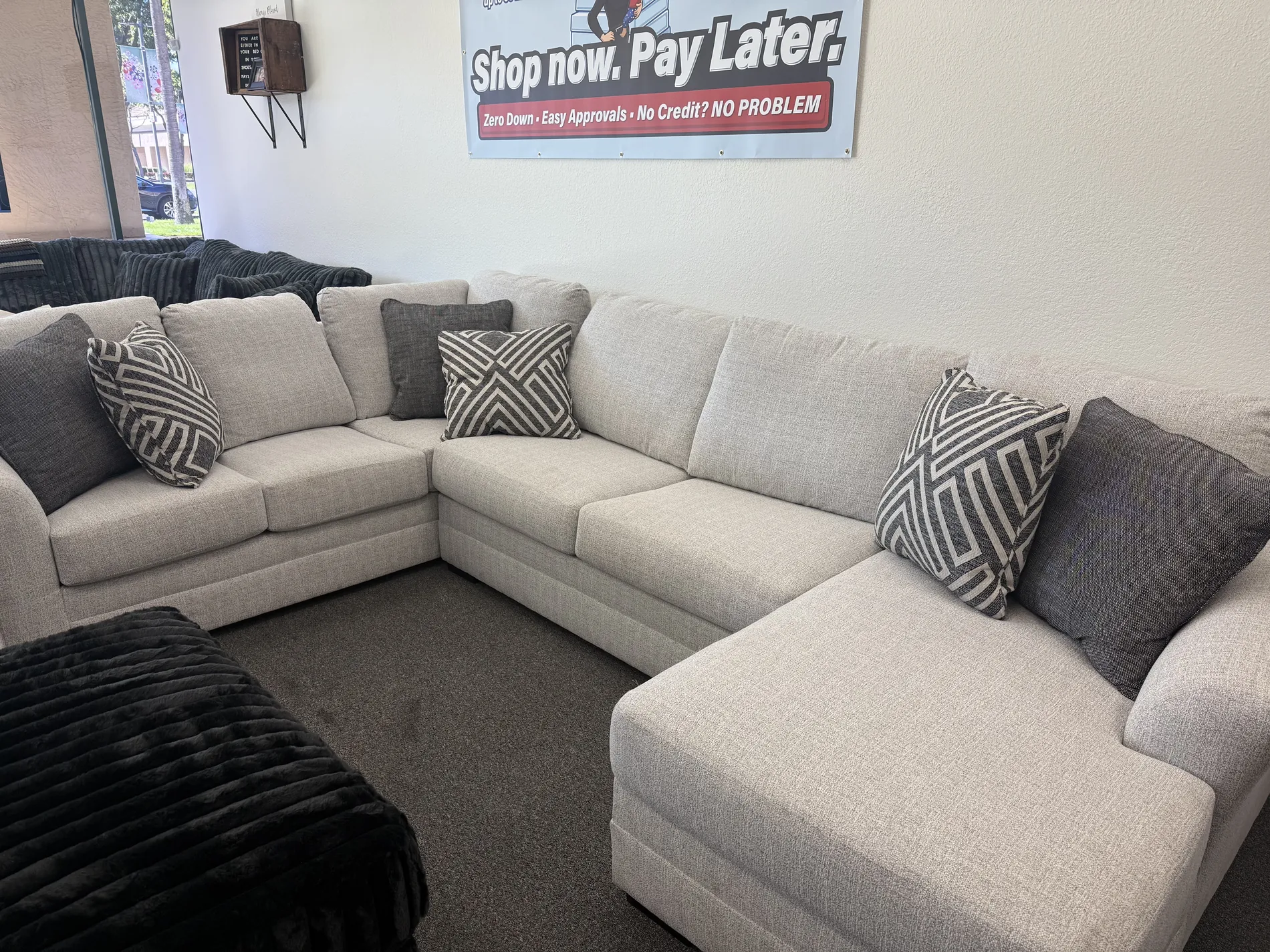Warm taupe sectional with white accent pillows